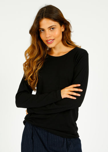 A woman smiling and wearing a black long-sleeved t-shirt with a round neckline.
