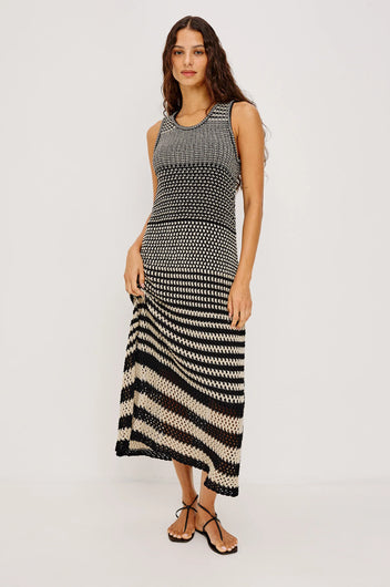 Woman wearing a black and white patterned dress on a light gray background